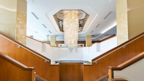 A grand staircase with wooden railings and a large chandelier. - Austria Trend Hotel Europa Graz Hauptbahnhof (Graz)