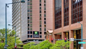 A Holiday Inn Express building with a prominent sign, surrounded by urban infrastructure including traffic lights and street signs.
