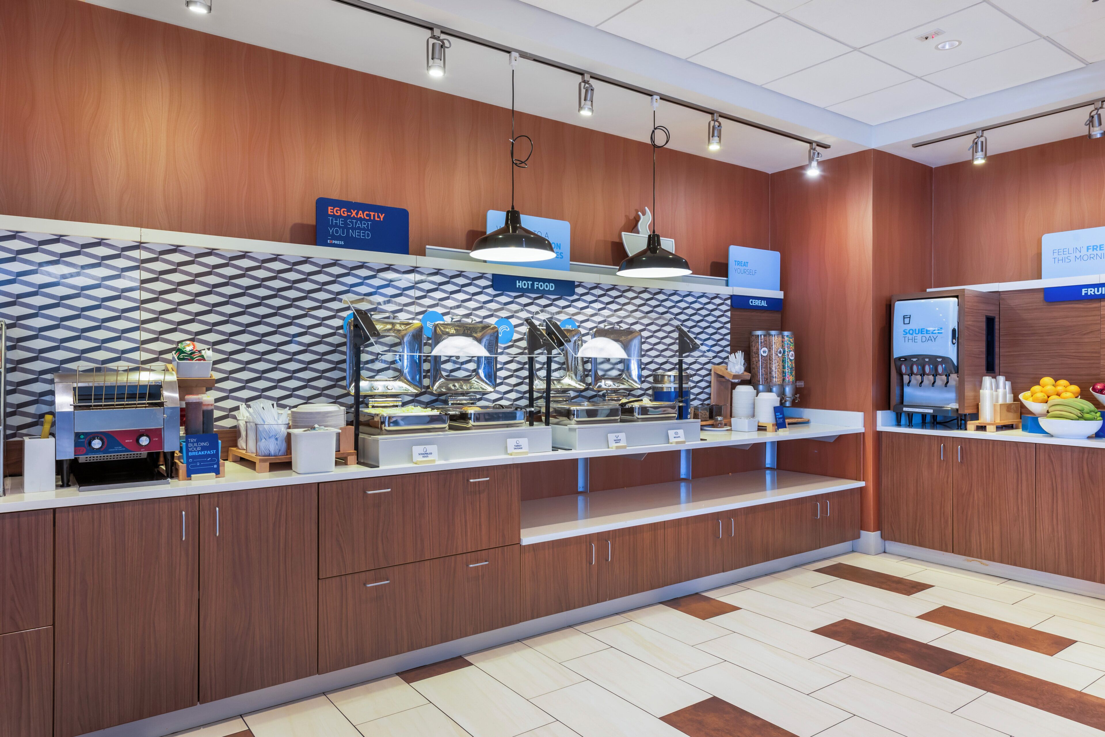 A modern breakfast area with a self-serve station, a coffee machine, and a fruit display.