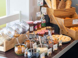 Una exhibición de alimentos con varios frascos de mermeladas, pan y pasteles.