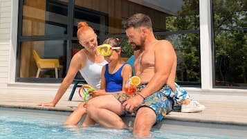 Una piscina al aire libre de temporada, sombrillas, tumbonas