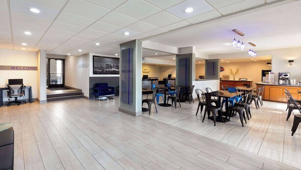 A modern office space with a reception area, meeting rooms, and a dining area with tables and chairs. - Baymont by Wyndham Nashville (Nashville)