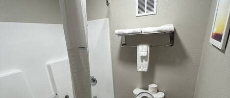 Un baño con bañera, inodoro y ducha.