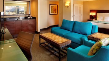 Une chambre d’hôtel avec vue sur la ville, comprenant un canapé, une table basse, un bureau et un lit.