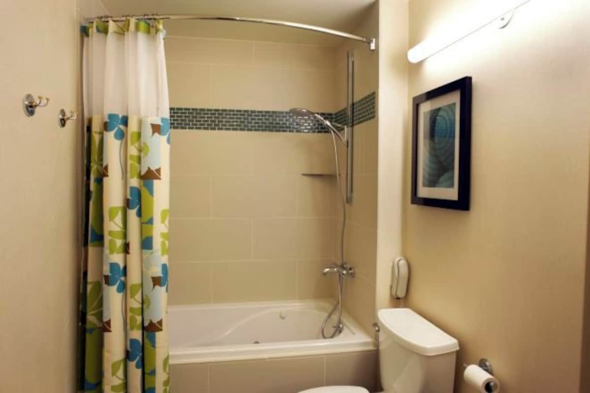 A bathroom with a bathtub, toilet, and shower.