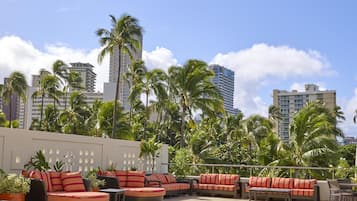 Una piscina al aire libre, sombrillas, sillones reclinables de piscina