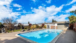 Una piscina rectangular con revestimiento azul, rodeada por una plataforma de hormigón.