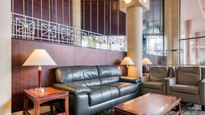 A lobby with a leather sofa, two armchairs, a wooden coffee table, and two lamps. - Quality Inn & Suites Tarpon Springs South (Tarpon Springs)