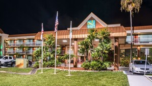 A hotel with a sign reading "Quality Inn & Suites" and a flag in front. - Quality Inn & Suites Tarpon Springs South (Tarpon Springs)