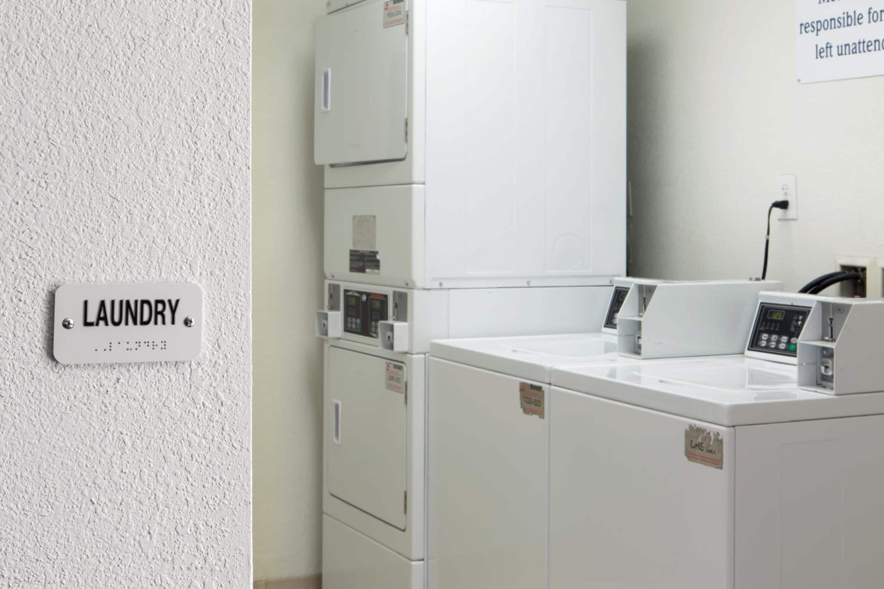 A laundry area with a sign labeled "LAUNDRY" and stacked washing machines.
