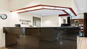 A reception desk with a clock and a sign reading 'POTOMAC MILLS.' - Best Western Potomac Mills (Woodbridge)