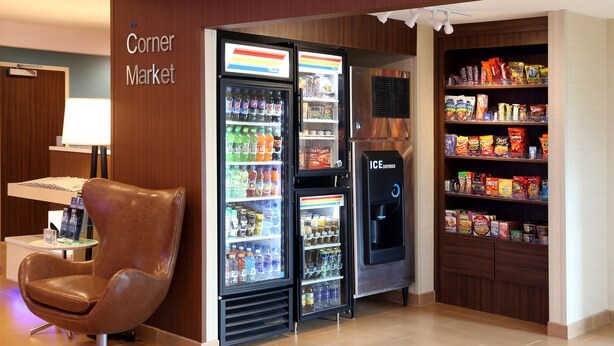 A corner market with a vending machine, a refrigerator stocked with beverages, and shelves of snacks. - Quality Inn Cranberry Township (Cranberry Township)