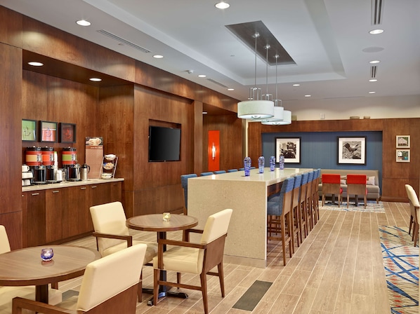 A hotel lobby with a bar area, seating arrangements, and a television screen. - Hampton Inn by Hilton Halifax Downtown (Halifax)