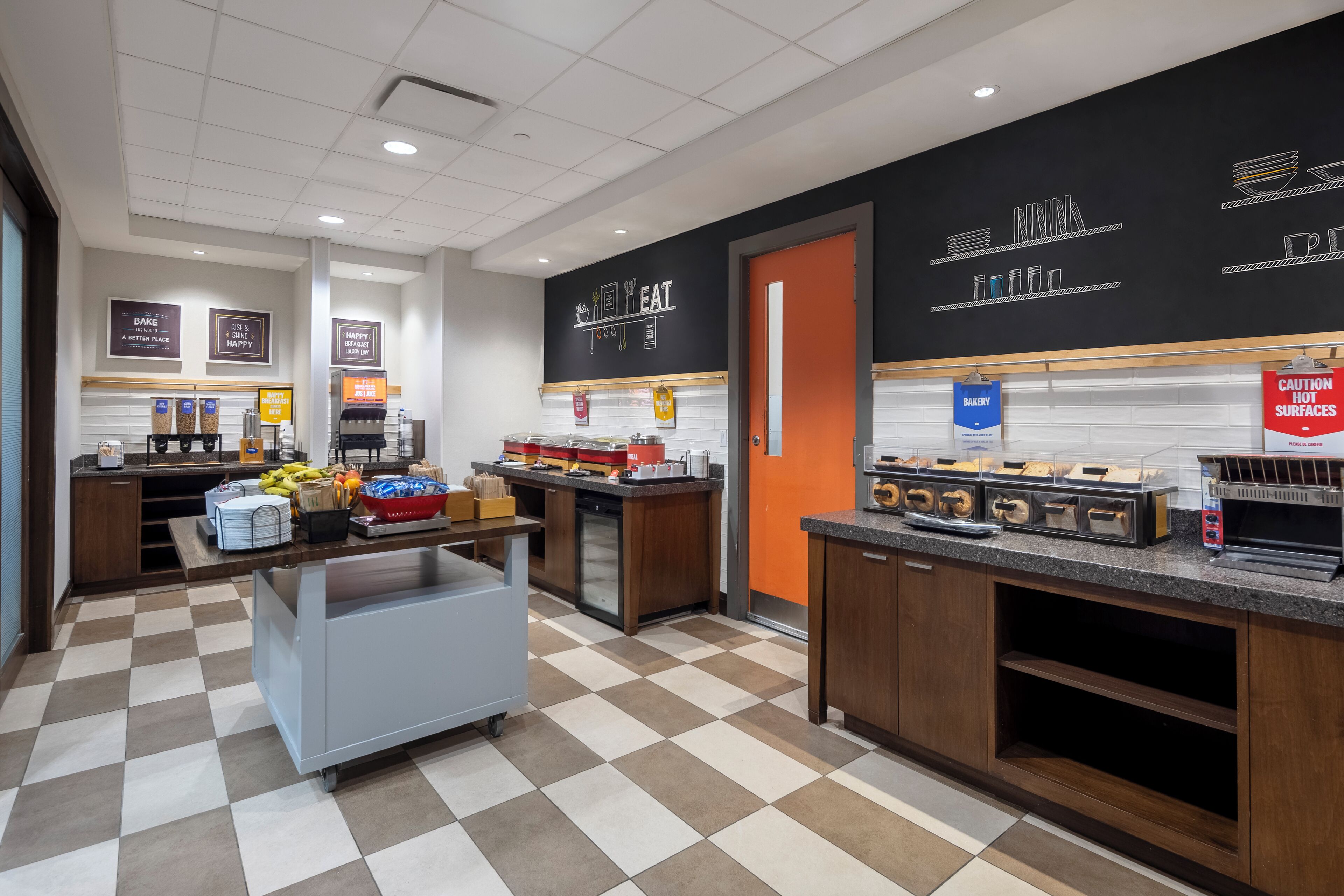 A bakery counter with various baked goods and a coffee station.
