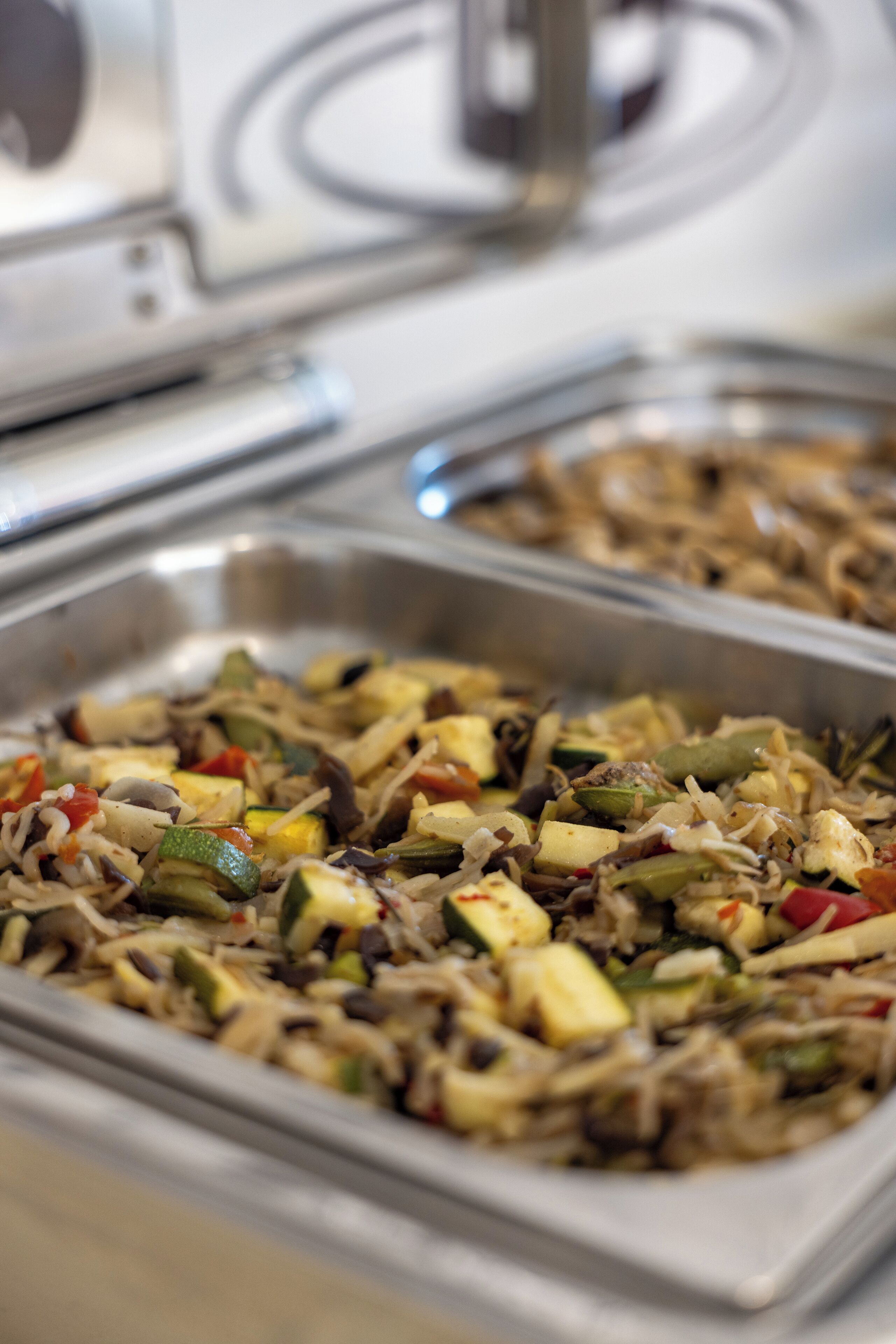 A buffet with various dishes including rice, vegetables, and meat.