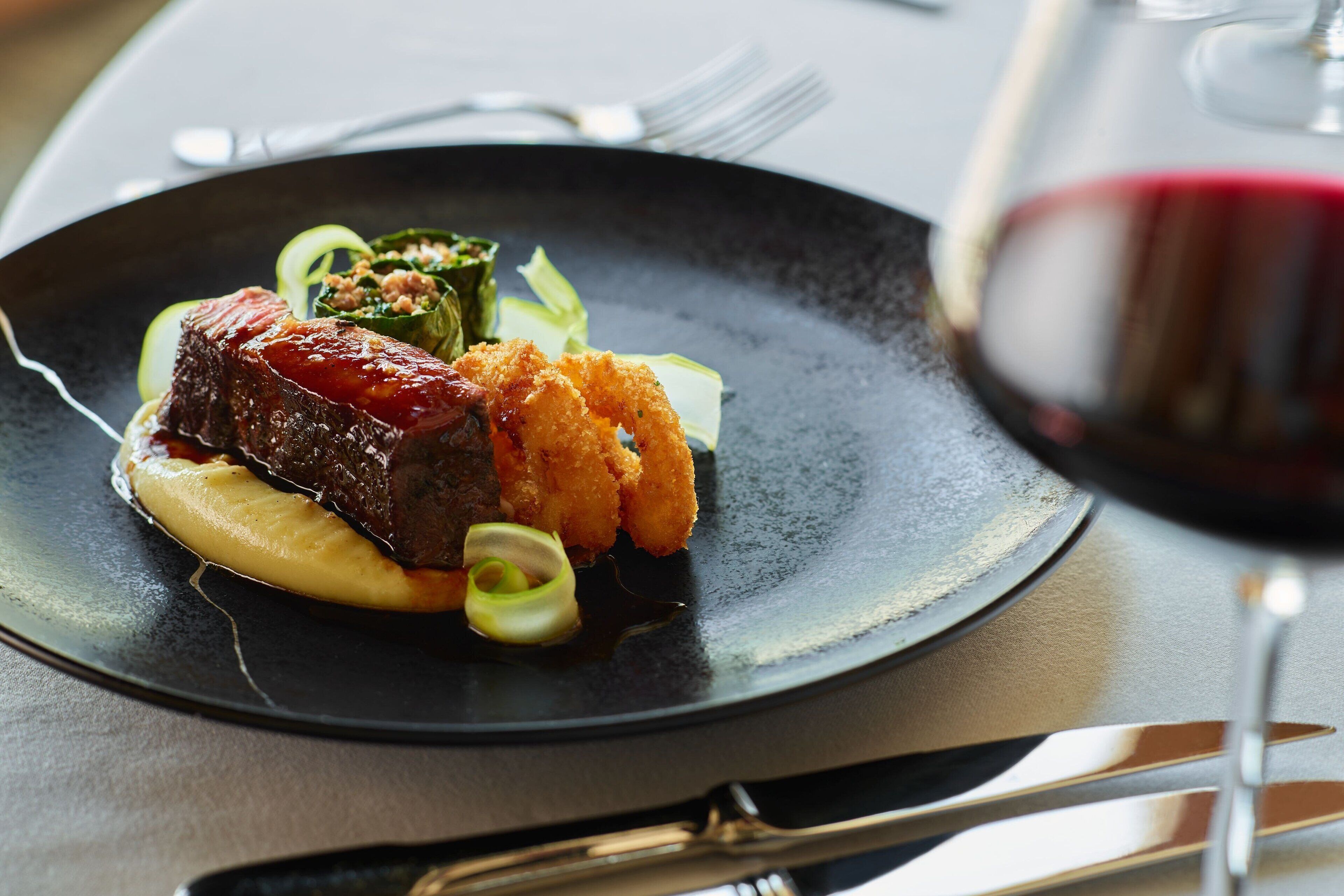 Ein Teller Essen mit einem Glas Rotwein.