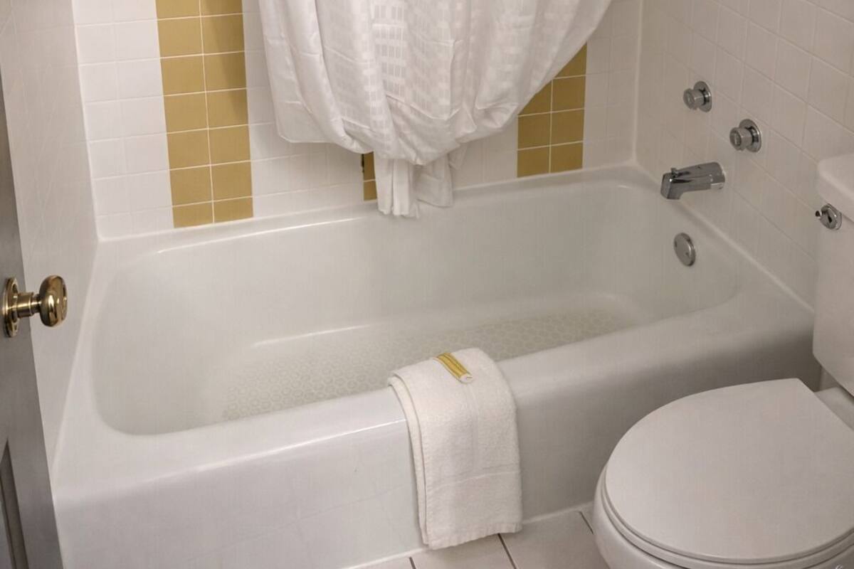 Ein Badezimmer mit Badewanne, Toilette und Duschvorhang.