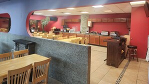 Un ristorante con bancone, zona salotto e cucina.