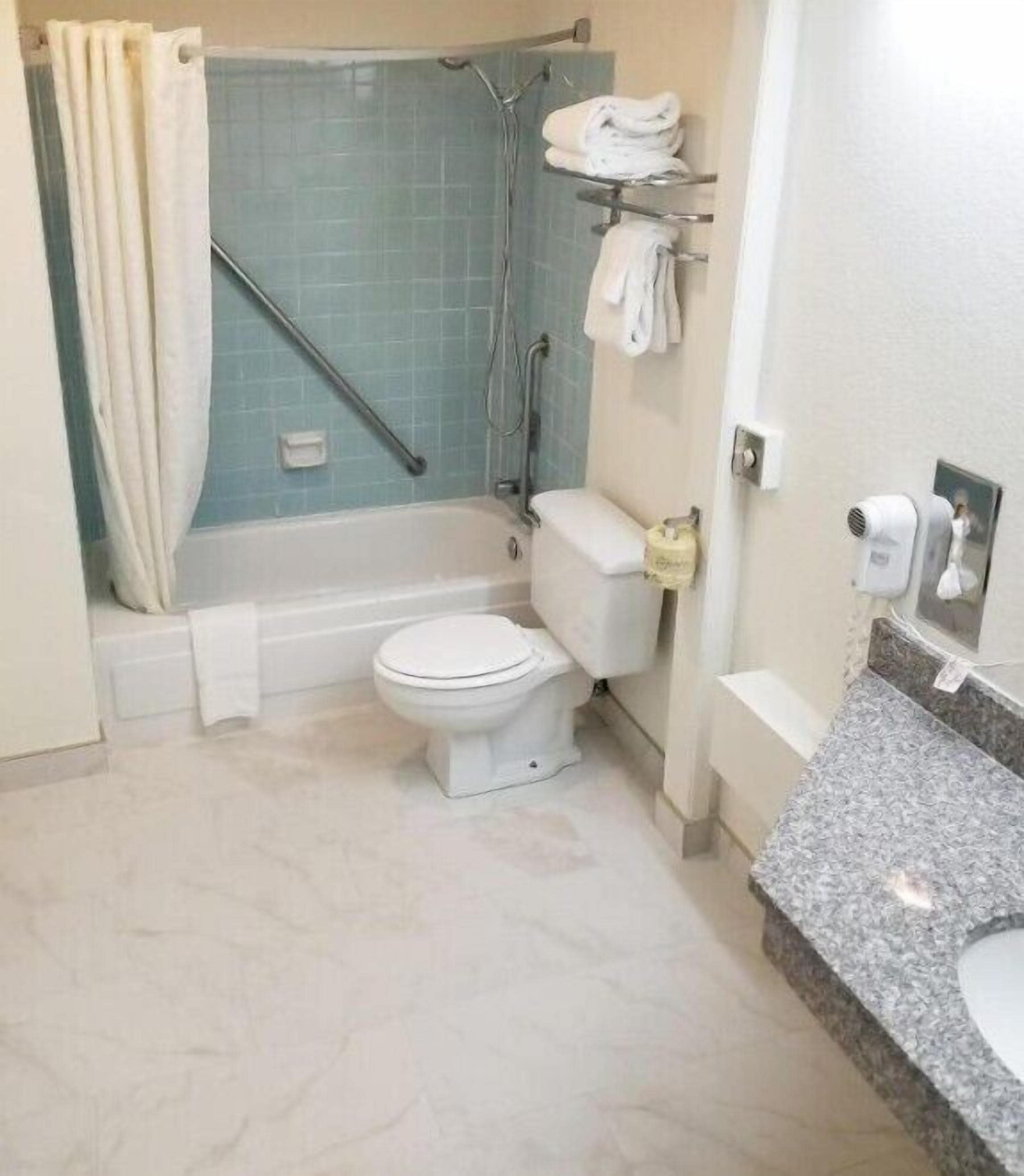 A bathroom with a shower, toilet, and a vanity with a sink.