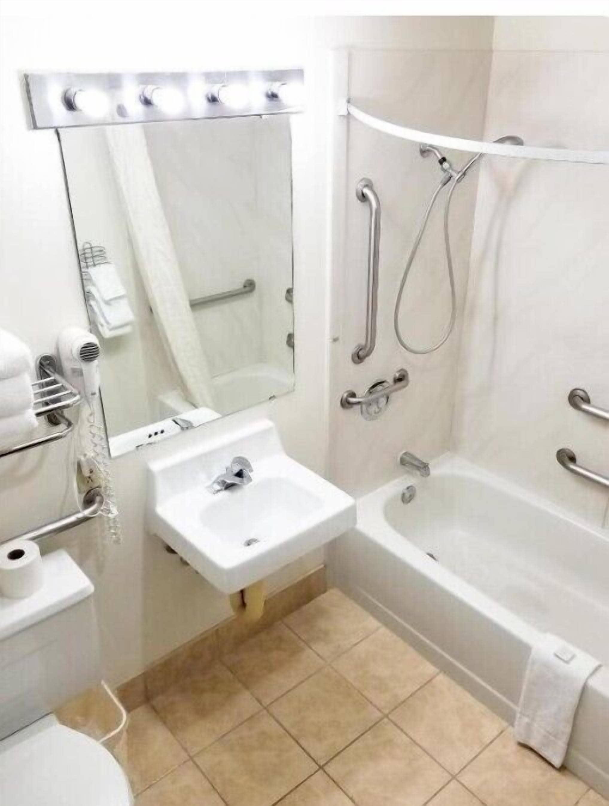 Un baño con lavamanos, espejo, ducha e inodoro.