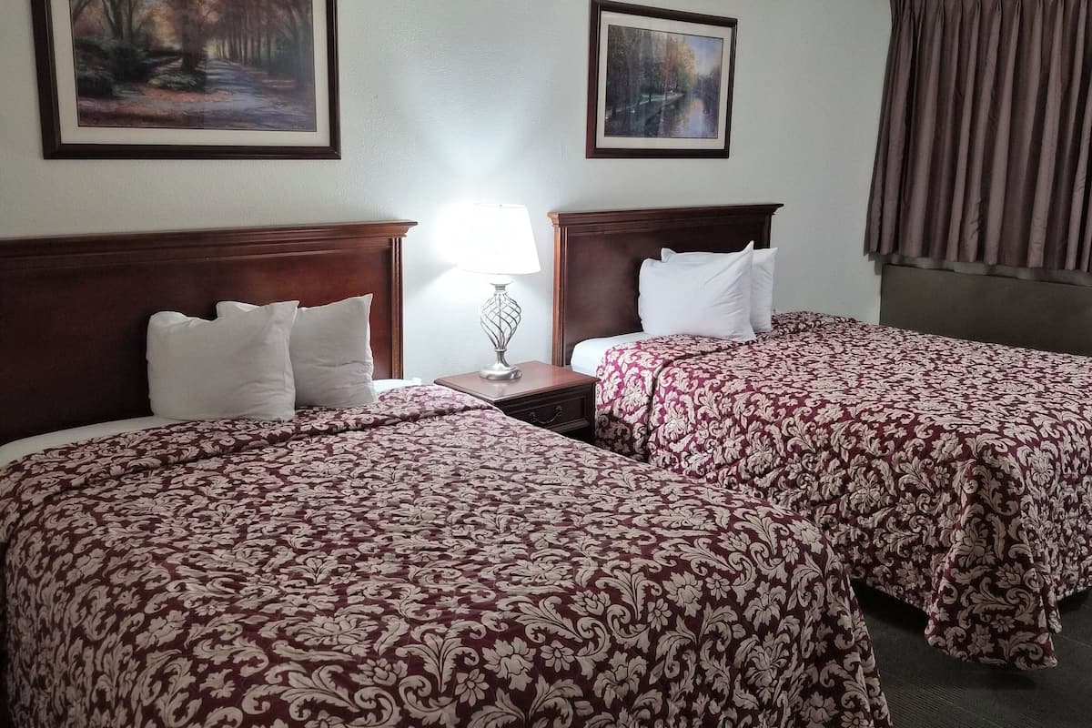 Senger med overmadrass, safe på rommet, skrivebord og blendingsgardiner