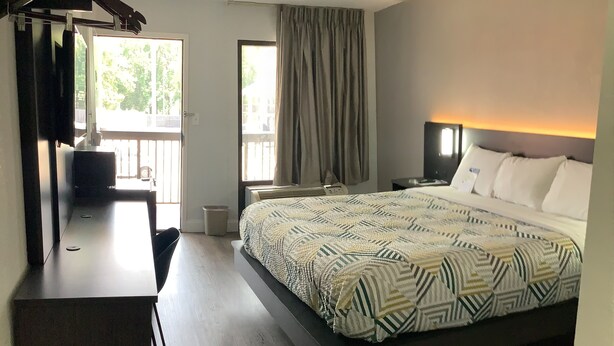 Een moderne hotelkamer met een groot bed, een bureau en uitzicht op de omgeving.
