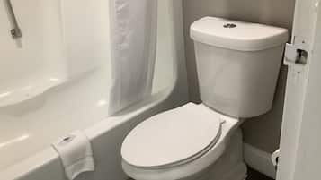 A bathroom with a white toilet, a bathtub, and a shower curtain.