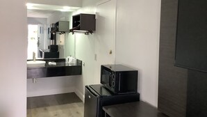 Een moderne badkamer met een wit wastafel, een zwart aanrecht en een zwarte koelkast.
