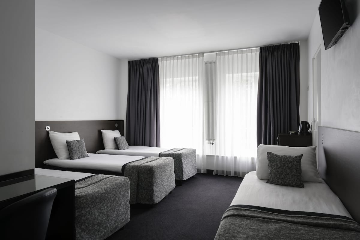 Ein Hotelzimmer mit zwei Betten, einem Schreibtisch und einem Stuhl.