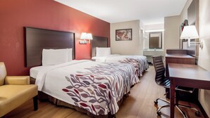 A hotel room with two beds, a desk, a chair, a desk lamp, and a wall-mounted TV. - Red Roof Inn Acworth - Emerson/ LakePoint South (Acworth)