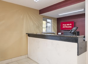 Una reception con un cartello che indica Wi-Fi gratuito in tutte le camere.