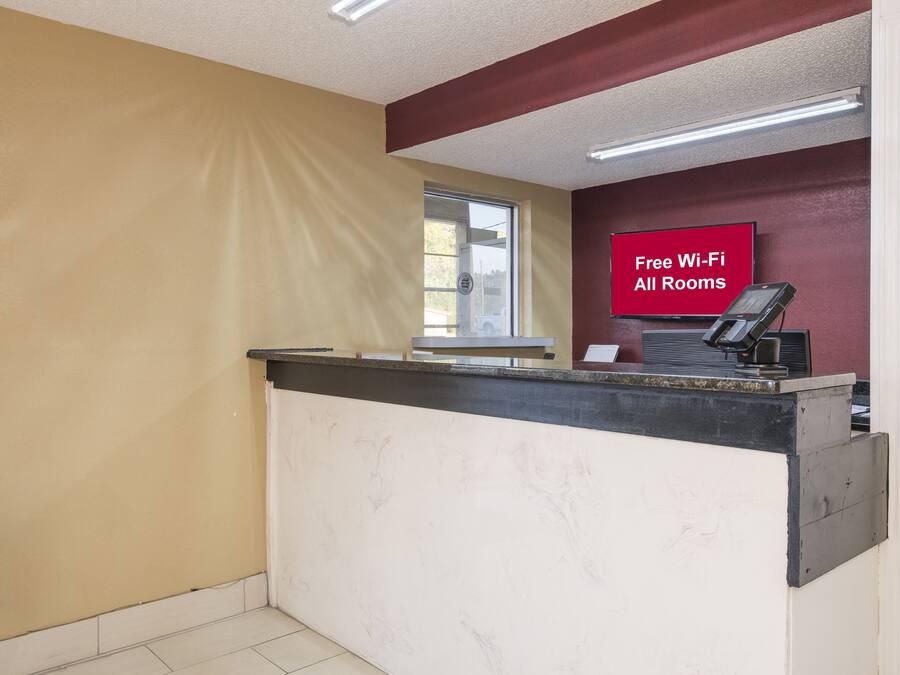 Bancada de recepção com placa indicando Wi-Fi gratuito em todos os quartos.