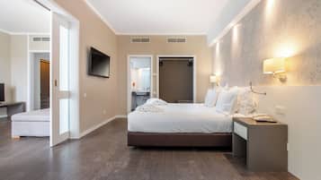 Quarto de hotel com cama, mesa de cabeceira, televisão e closet espaçoso.