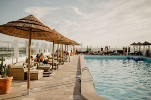 Una piscina al aire libre de temporada, sombrillas