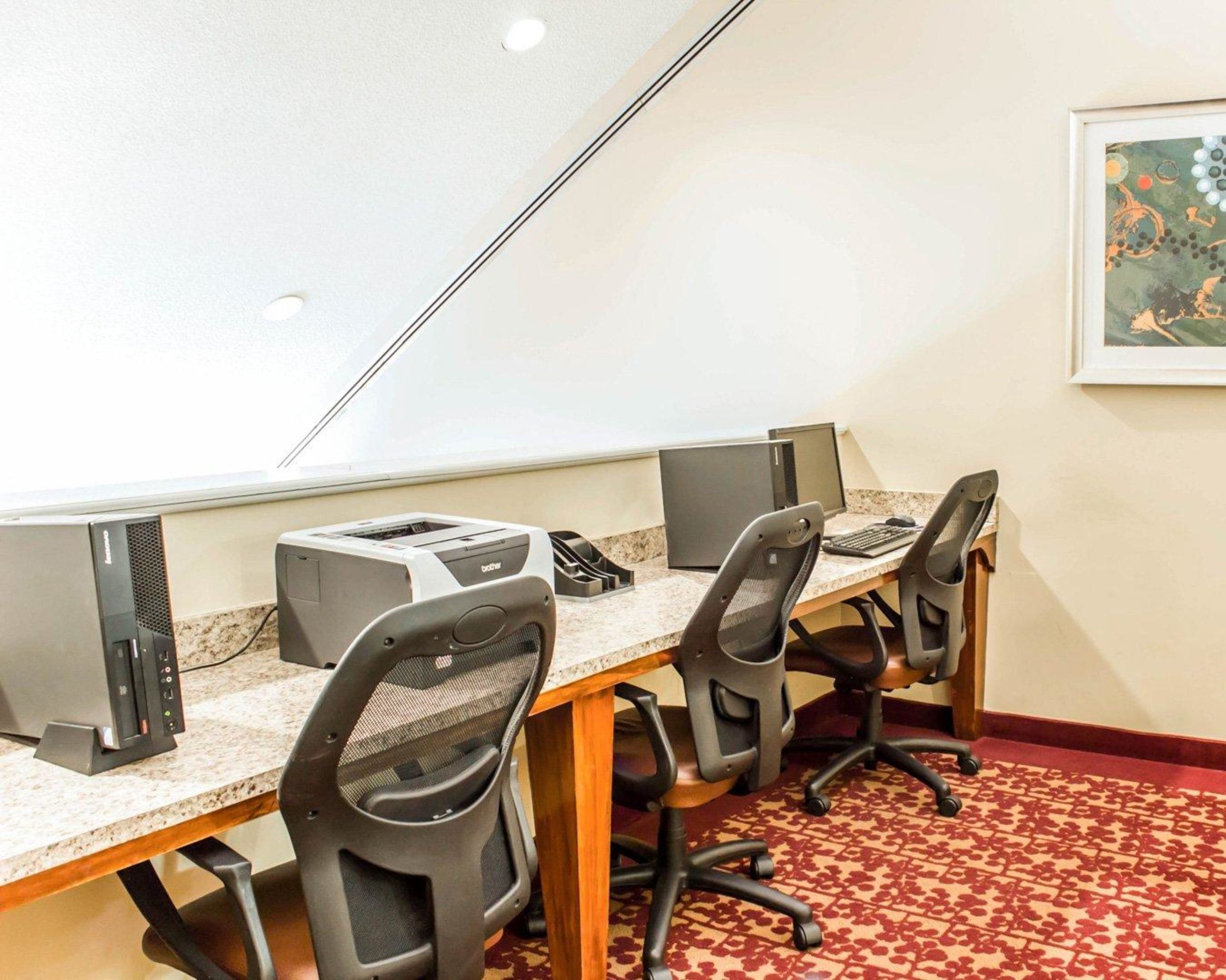 Une salle de conférence équipée d’une longue table, de quatre chaises de bureau, de deux ordinateurs de bureau et d’une imprimante.