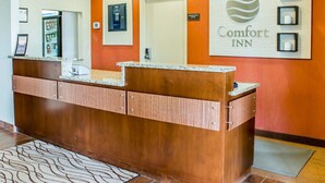 Ein Empfangsbereich mit einem Holzboden, einem großen Schild für Comfort Inn und einer Tür mit der Aufschrift 'Verwaltungsbüro'.