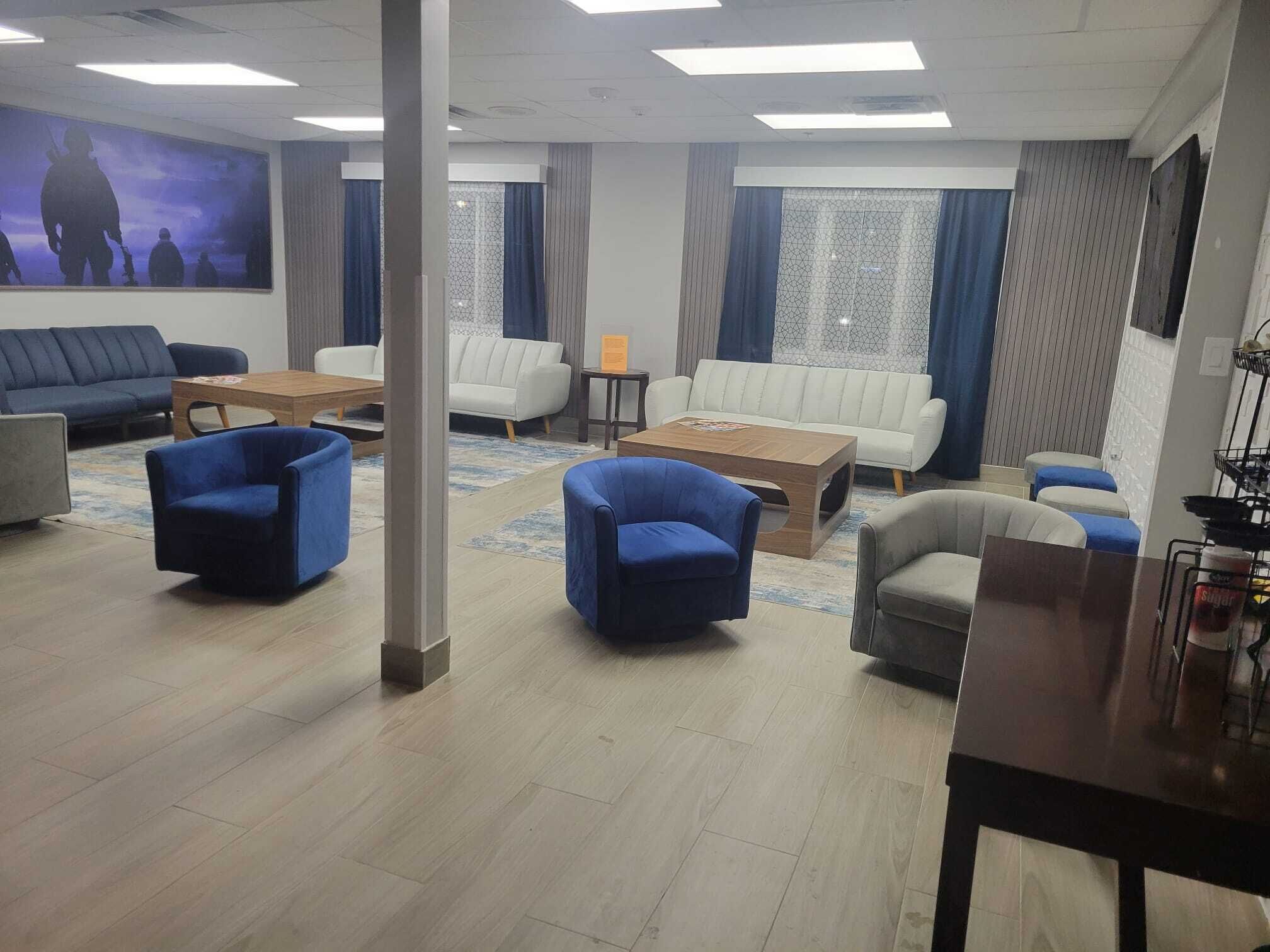 Un salon moderne avec des canapés, des fauteuils et une table basse.