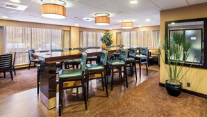 A conference room with a long table, multiple chairs, and a potted plant.