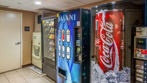 Vending machines with various beverages, a Coca-Cola machine, and an electrical room door.