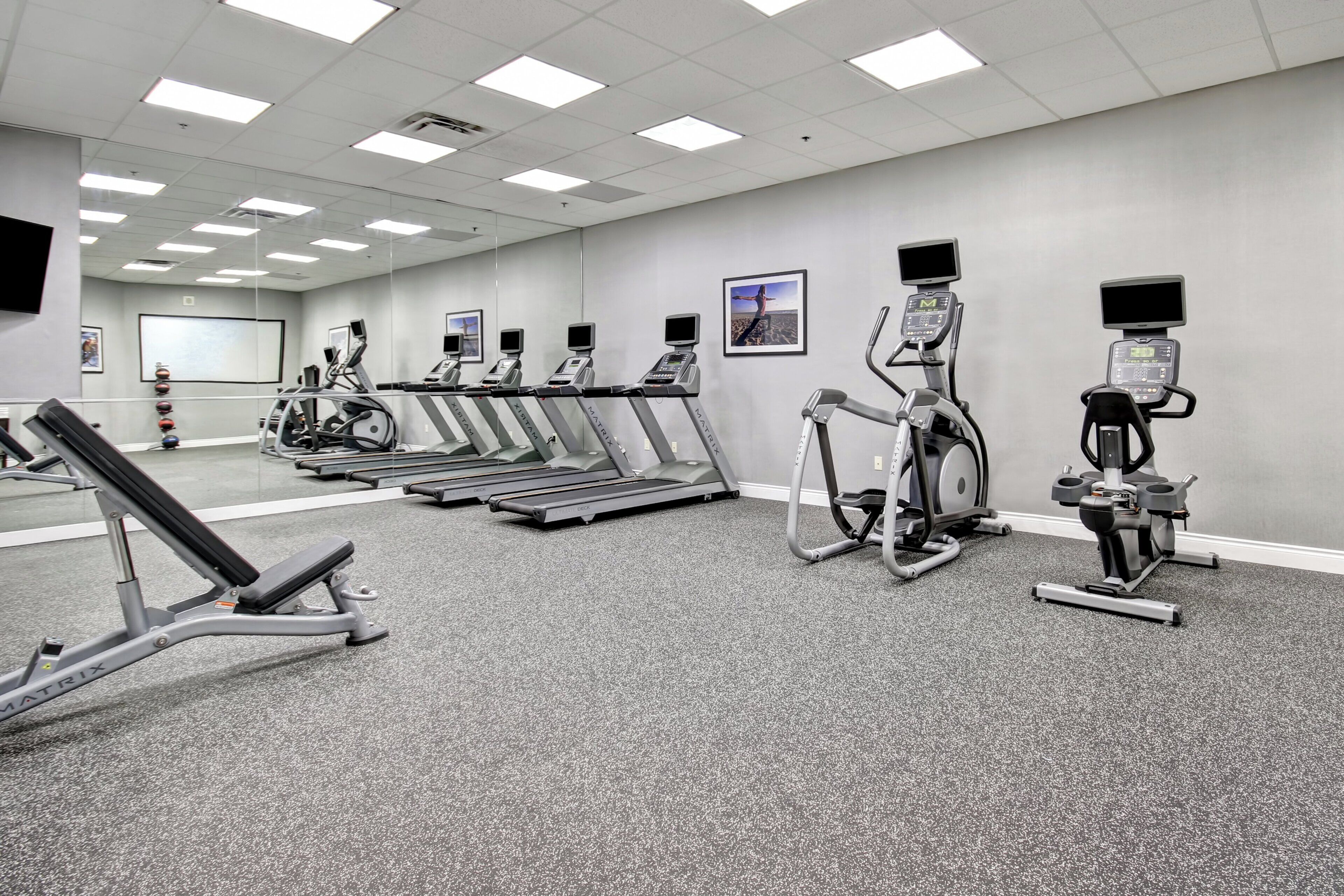 A gym with treadmills, elliptical machines, and weight equipment.