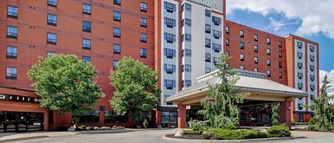 Ein Holiday Inn Hotel mit Ziegelbau, mehreren Etagen und einem überdachten Eingangsbereich.