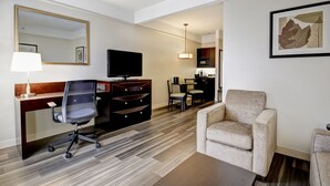 Une chambre d’hôtel équipée d’un bureau, d’une chaise, d’une télévision et d’un canapé.