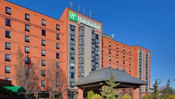 A Holiday Inn hotel with a brick facade, multiple floors, and a covered entrance area.