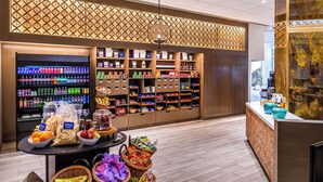A hotel lobby with a food display, a reception desk, and a decorative wall.