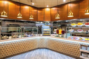 Enjoy a wide selection of food options at our buffet, featuring a variety of dishes displayed in bowls and trays.