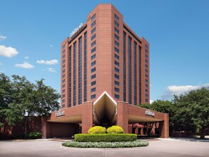 Standing tall, the Hilton building showcases a modern architectural design with a flat roof and vertical windows.