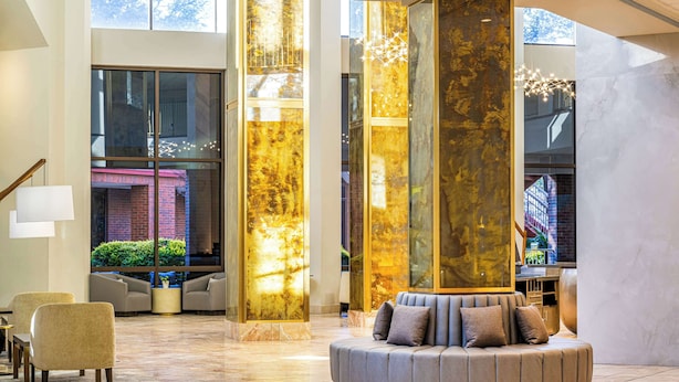 A spacious lobby with a modern design, featuring a curved seating area and large glass windows.