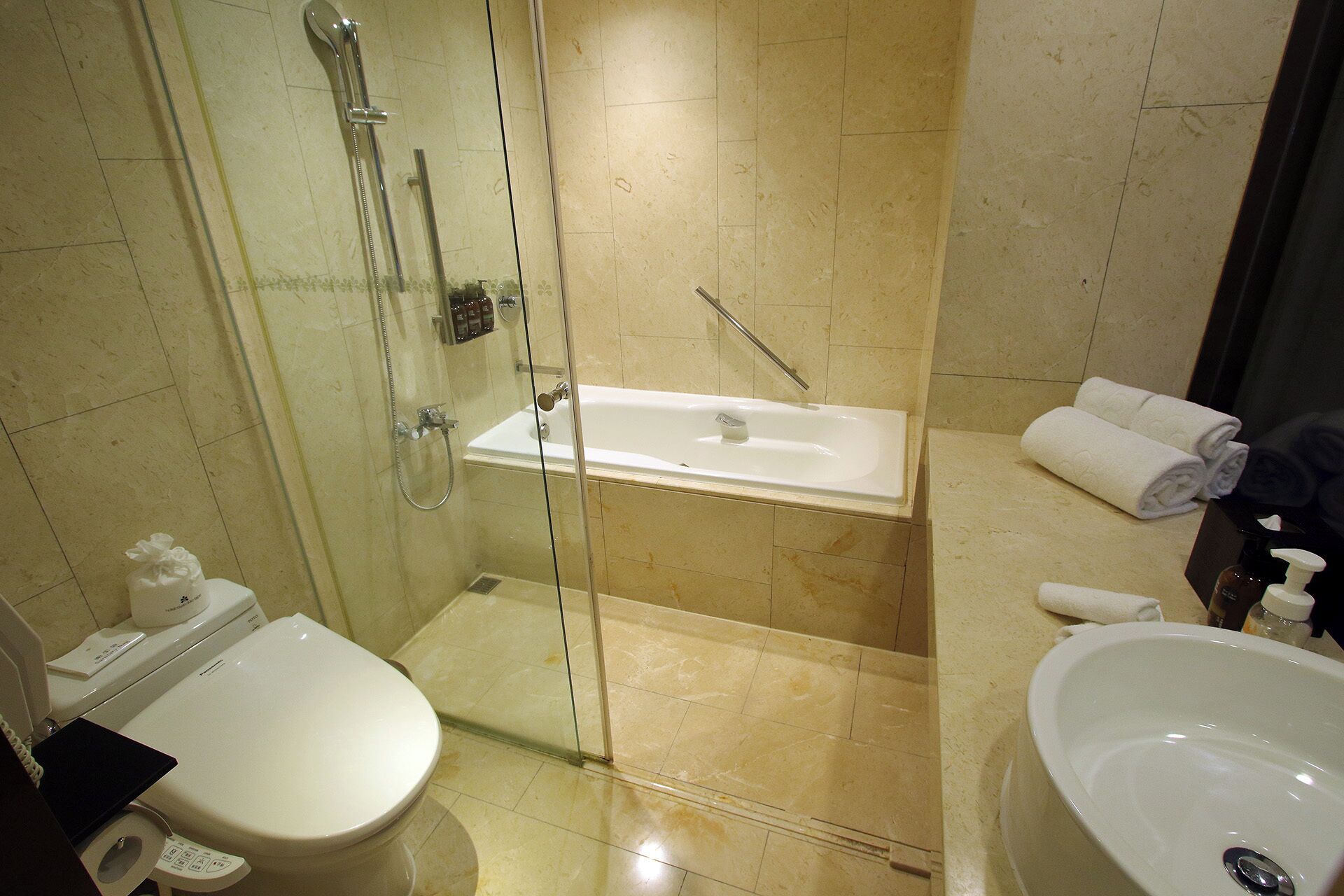 A bathroom with a toilet, a shower, and a sink.