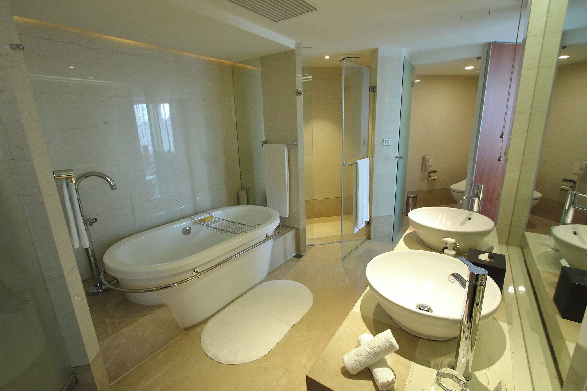 Un baño moderno con bañera, dos lavamanos y cabina de ducha de vidrio.