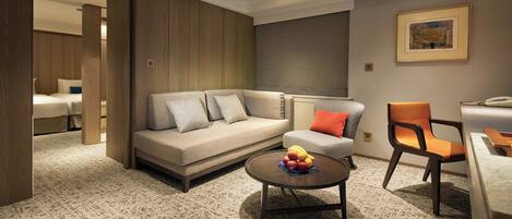 Uma sala de estar moderna com sofá, poltrona, mesa de centro e uma fruteira.
